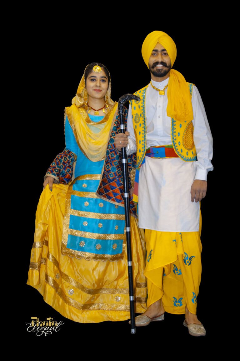 Indian couple in traditional yellow and blue embroidered dress standing against a black backdrop