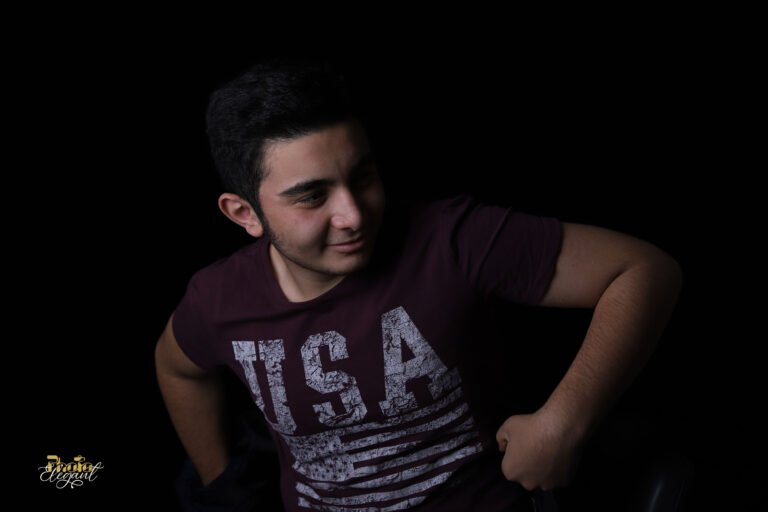 USA flag t-shirt portrait, teenage boy studio photo, patriotic youth portrait, American flag shirt photo, black background portrait, dramatic lighting photography, distressed USA shirt, teen model portrait, modern Americana photo, PhotoElegant studio shot