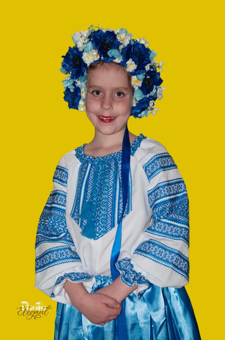 Smiling Ukrainian teenage girl in traditional dress on an egg yellow background